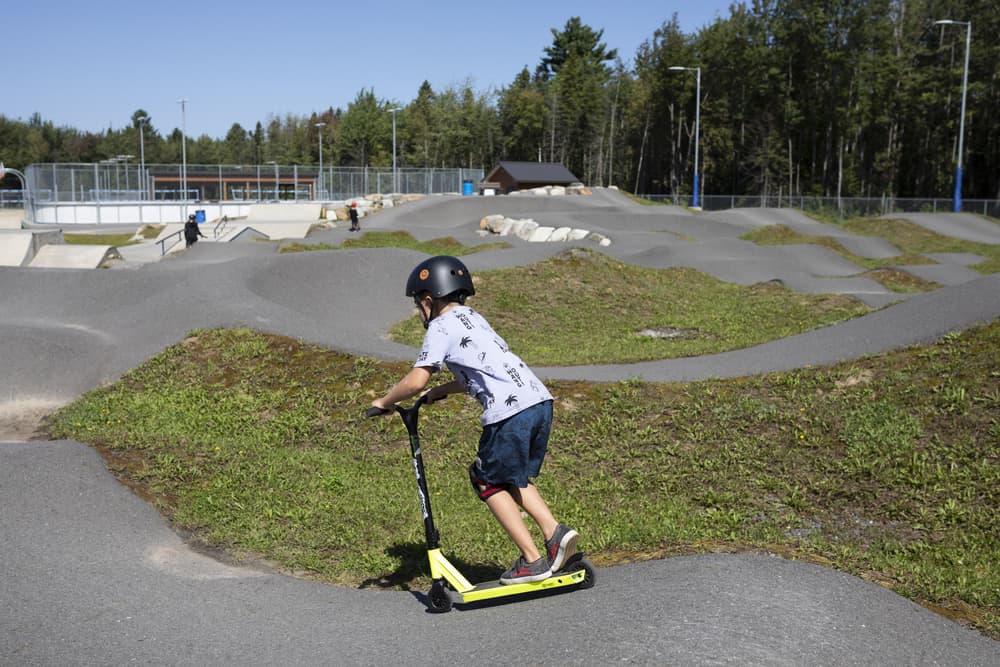 Enfant en trottinette dans un parc de skate