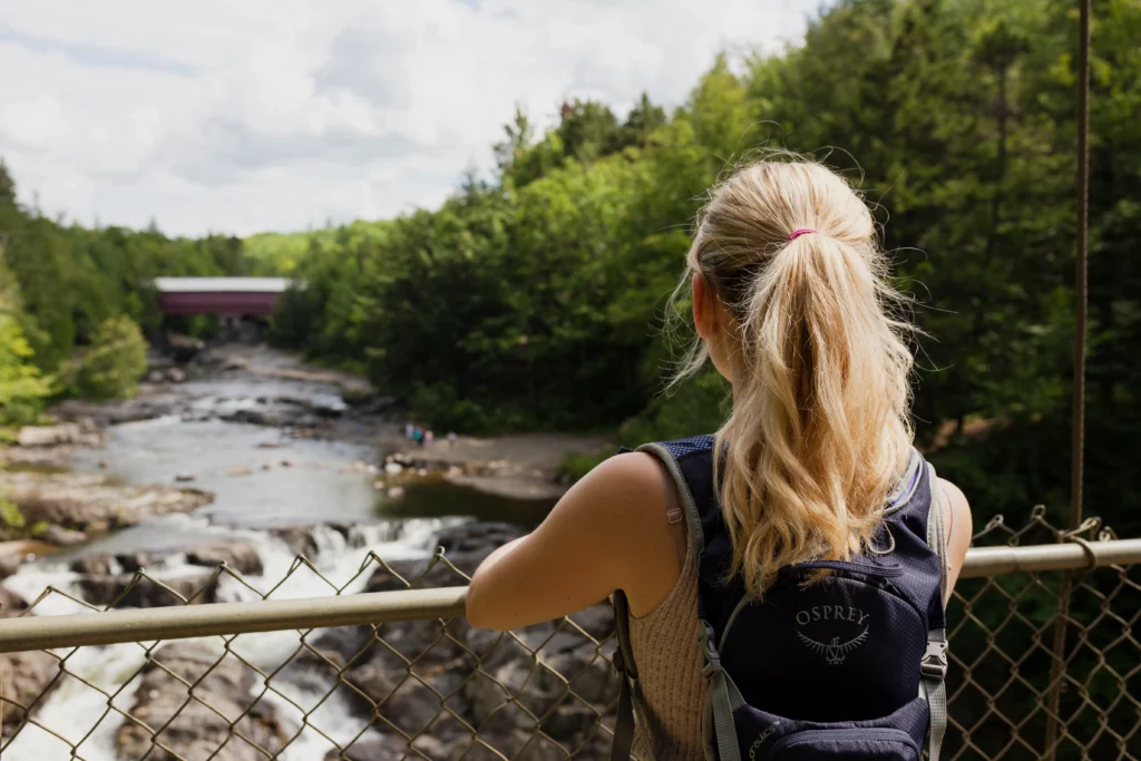 Personne observant rivière depuis un pont.