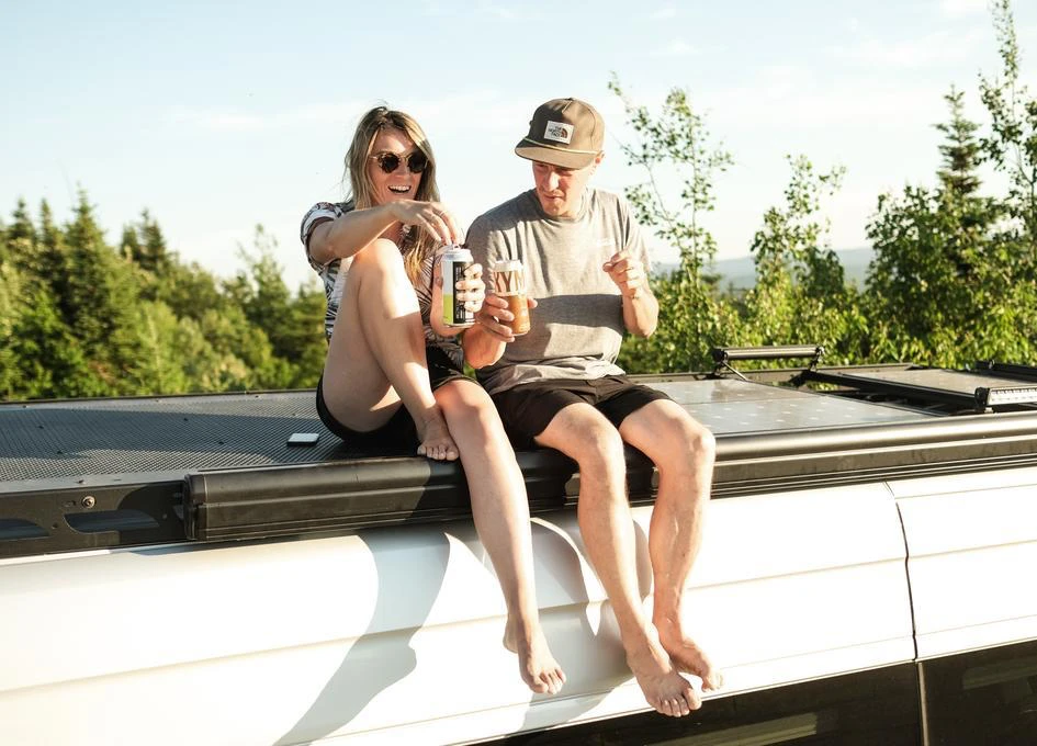 Couple assis sur un van avec boissons.