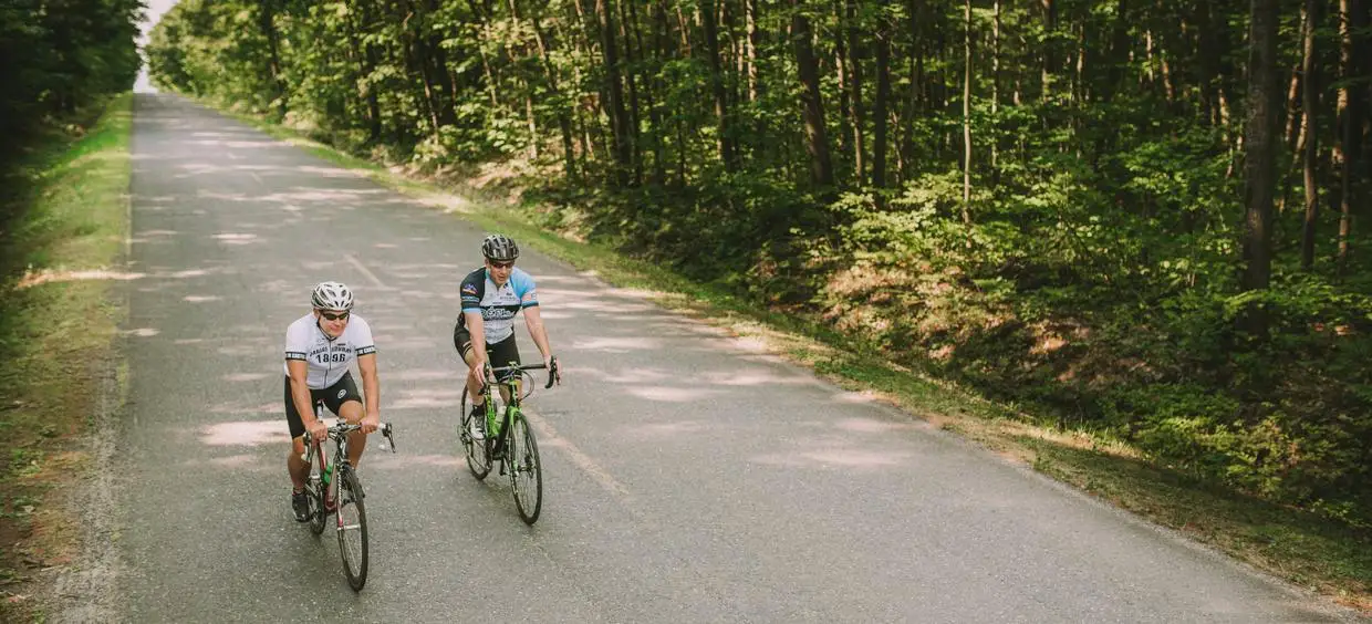 Deux cyclistes sur une route forestière.