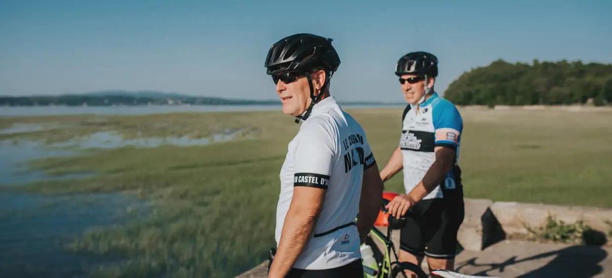 Cyclistes en bord de mer sous le soleil.