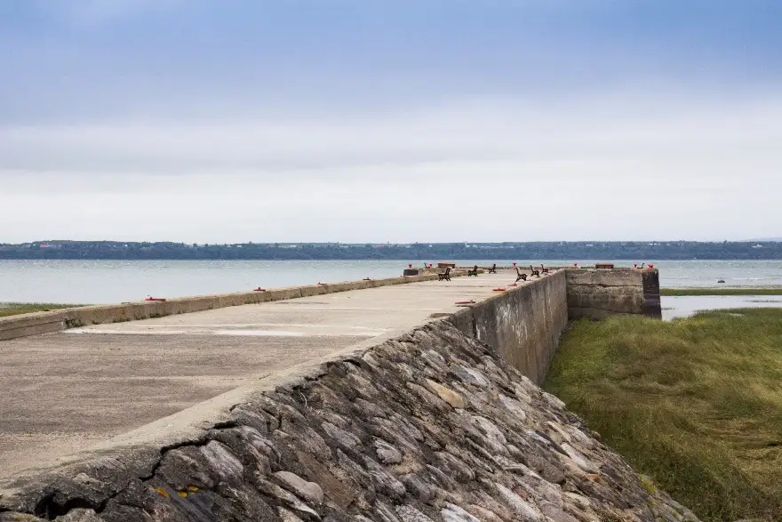 Jetée en pierre face à la mer grise.