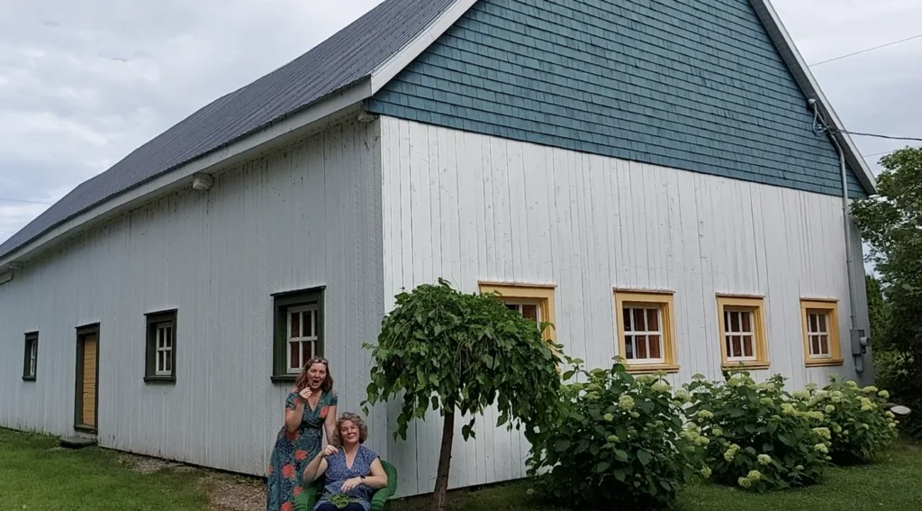 Deux personnes devant une grange et des arbres