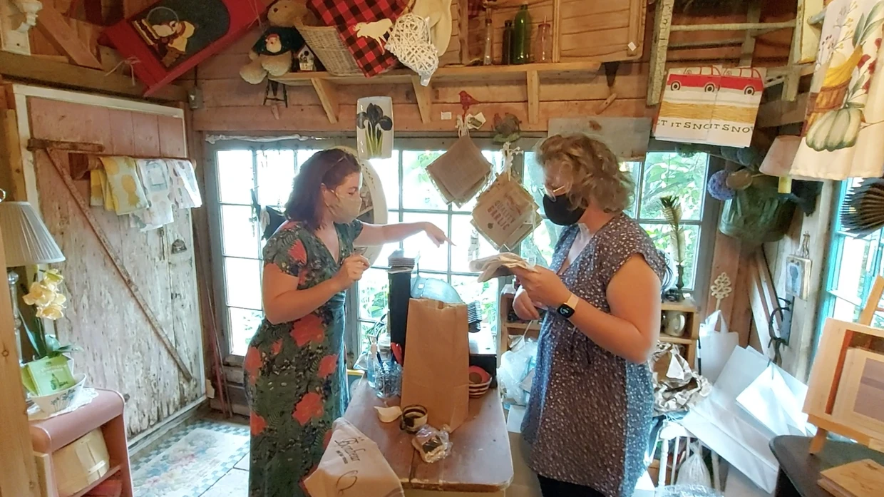 Deux femmes discutent dans une boutique d'artisanat.