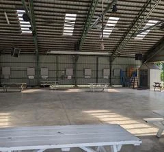 Grand hangar avec des tables blanches.