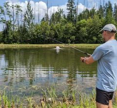 Homme pêchant au bord du lac paisible.