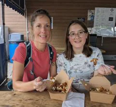 Deux femmes souriantes dégustent un repas.