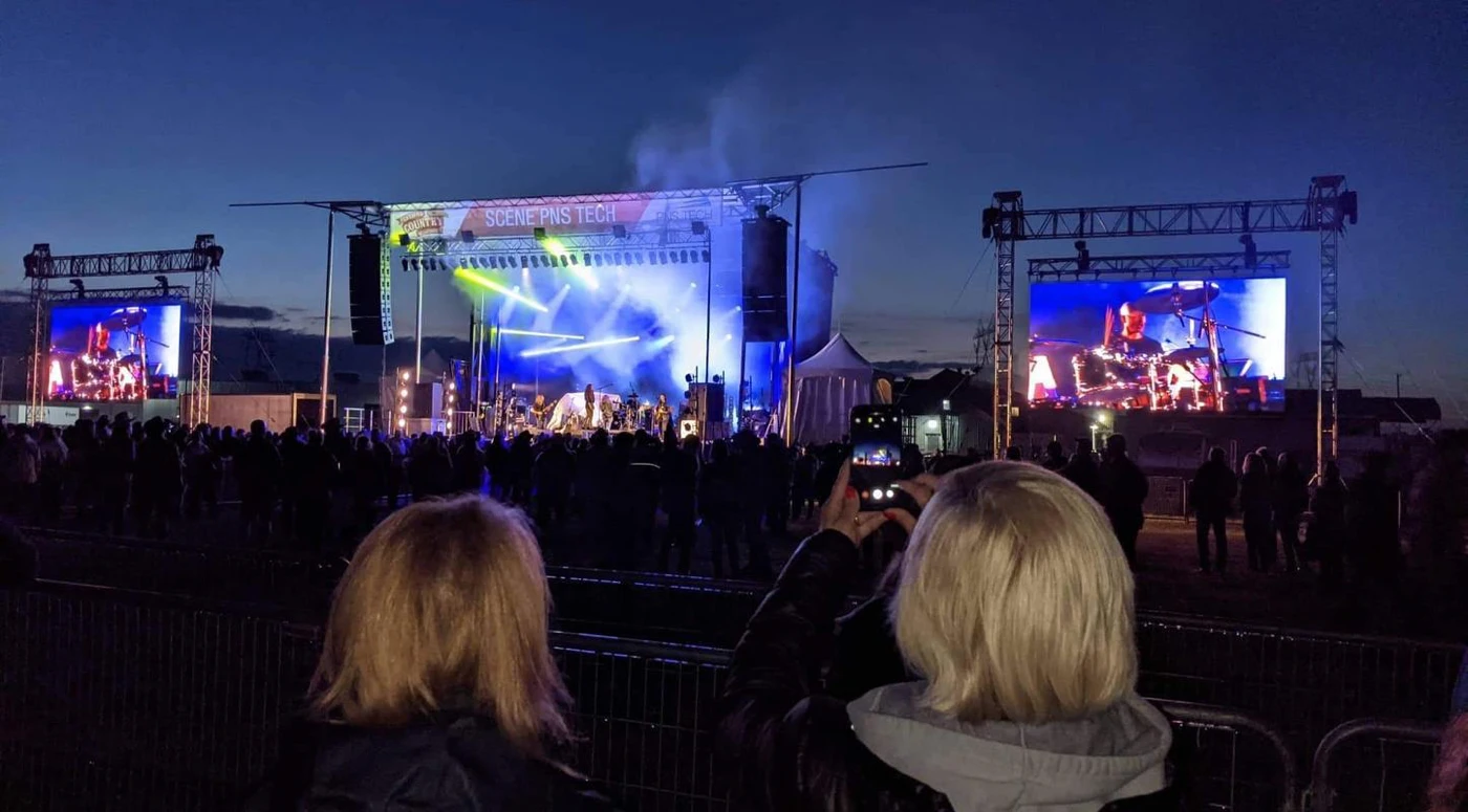 Concert en plein air avec écran géant la nuit.