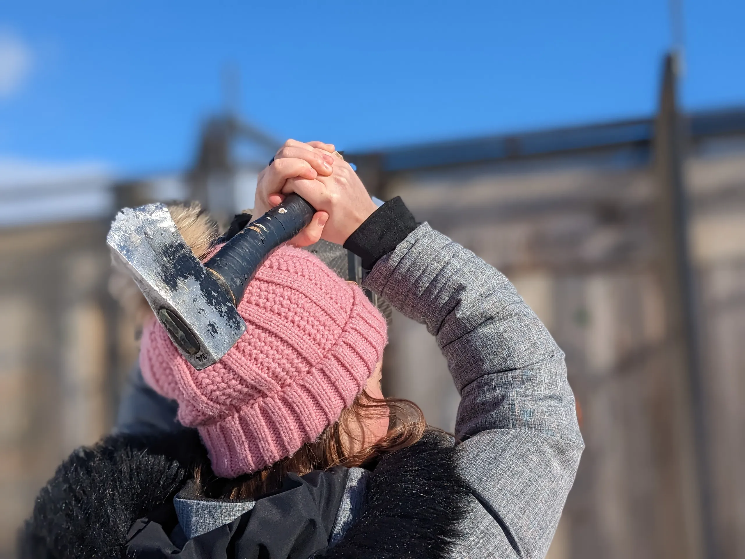 Personne portant un bonnet rose avec une hache.