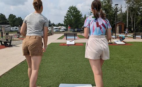 Deux femmes jouant au jeu de lancer de sacs.