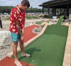 Personne jouant au mini-golf en plein air.