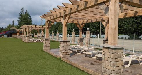 Terrasse avec pergolas en bois et chaises longues.