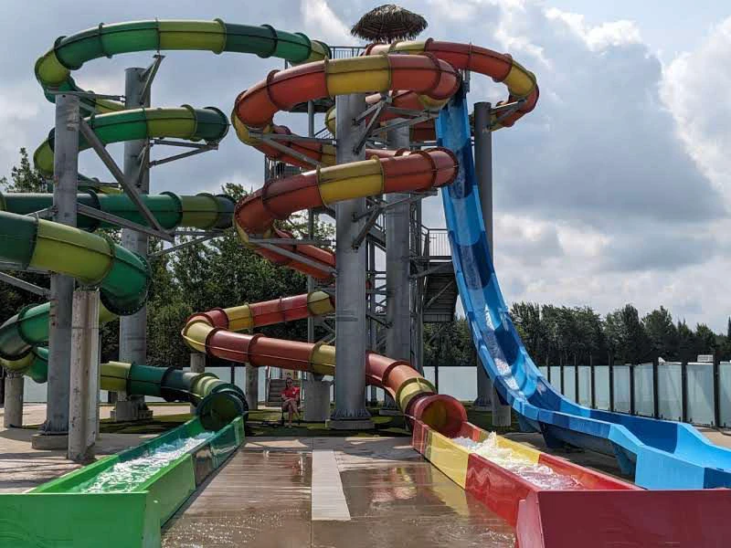 Toboggans colorés au parc aquatique sous le ciel.