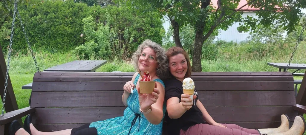 Deux femmes dégustant des glaces sur une balançoire.