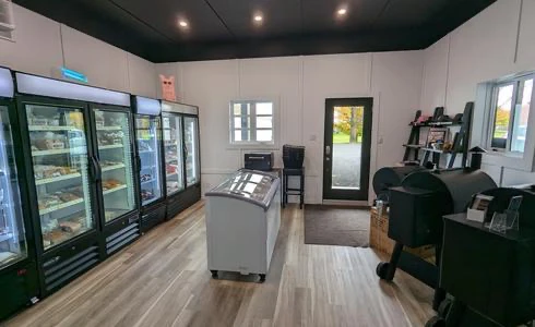 Intérieur d'une épicerie avec congélateurs et étagères.