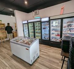 Magasin avec congélateurs et réfrigérateurs remplis de produits.