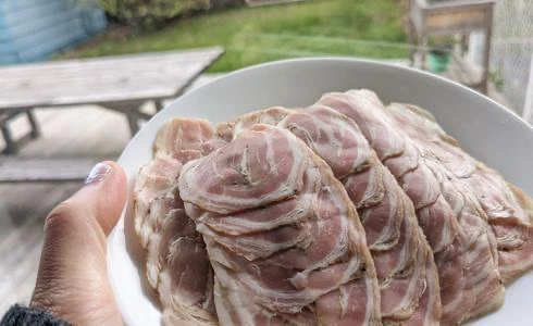 Assiette de viande en tranches, présentée en extérieur.