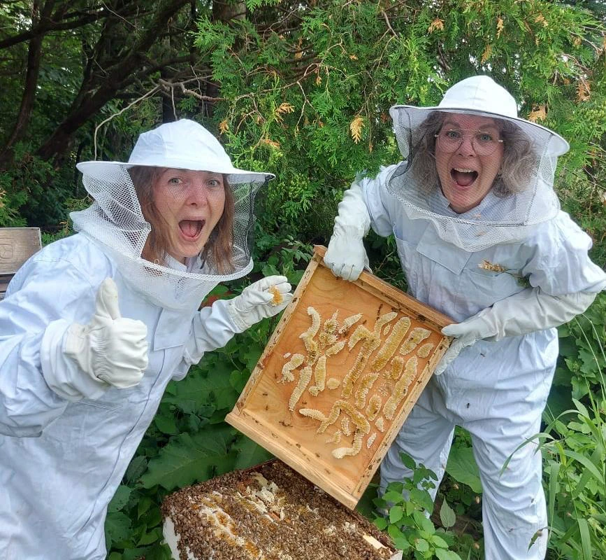 Deux apiculteurs heureux avec cadre de ruche.