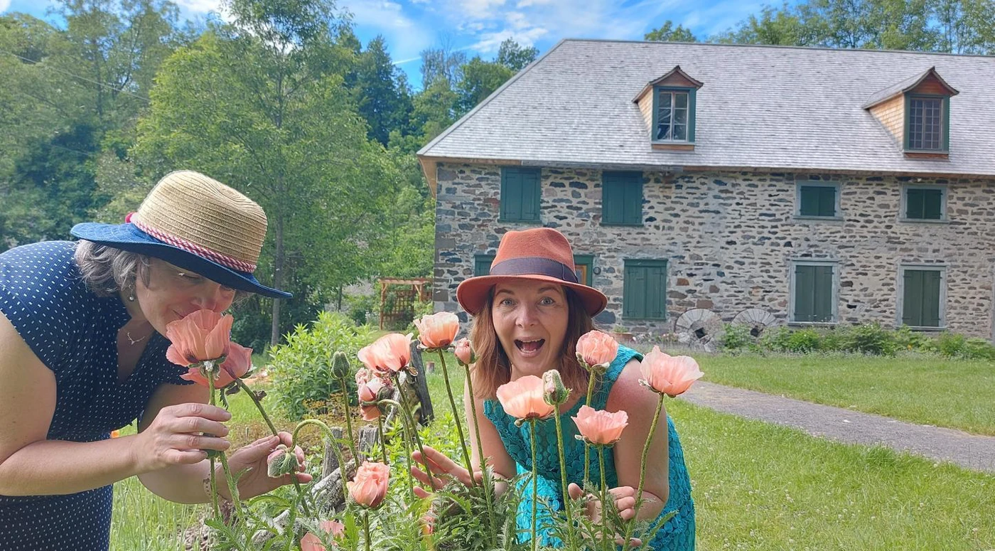 Deux femmes souriantes avec des coquelicots.