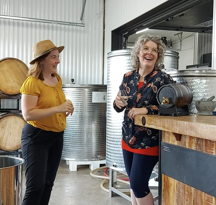 Deux femmes discutent dans une distillerie artisanale.