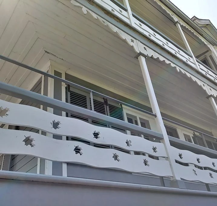 Façade maison bois avec balcon décoratif.