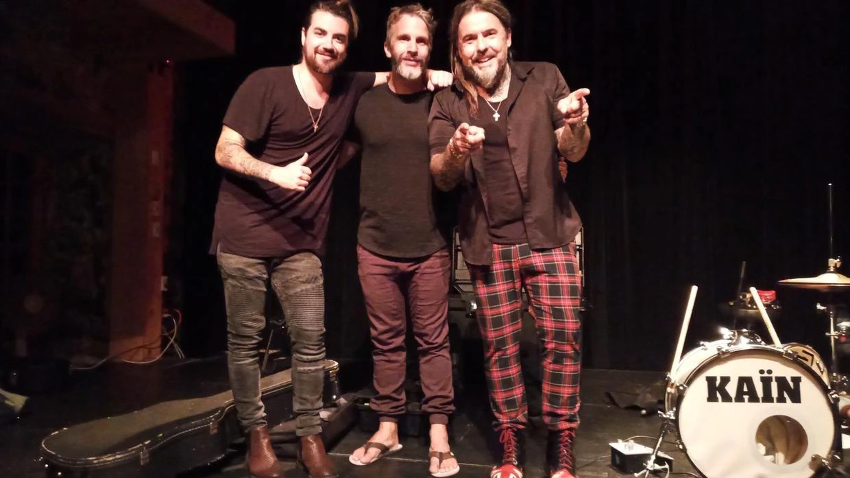 Trois musiciens posant sur scène avec batterie Kaïn.