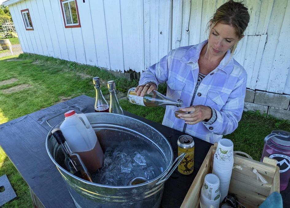 Femme servant du jus à l'extérieur d'une ferme