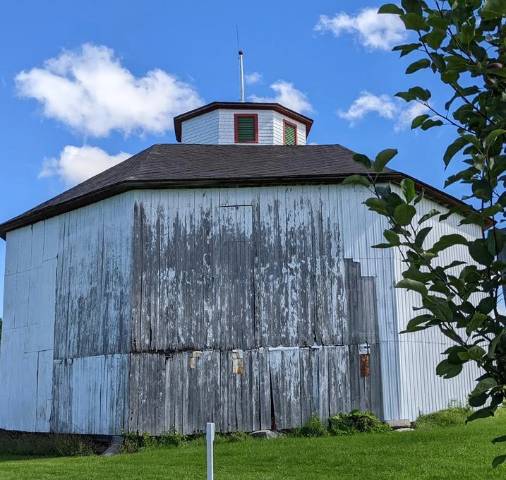 Grange octogonale en bois sous ciel bleu