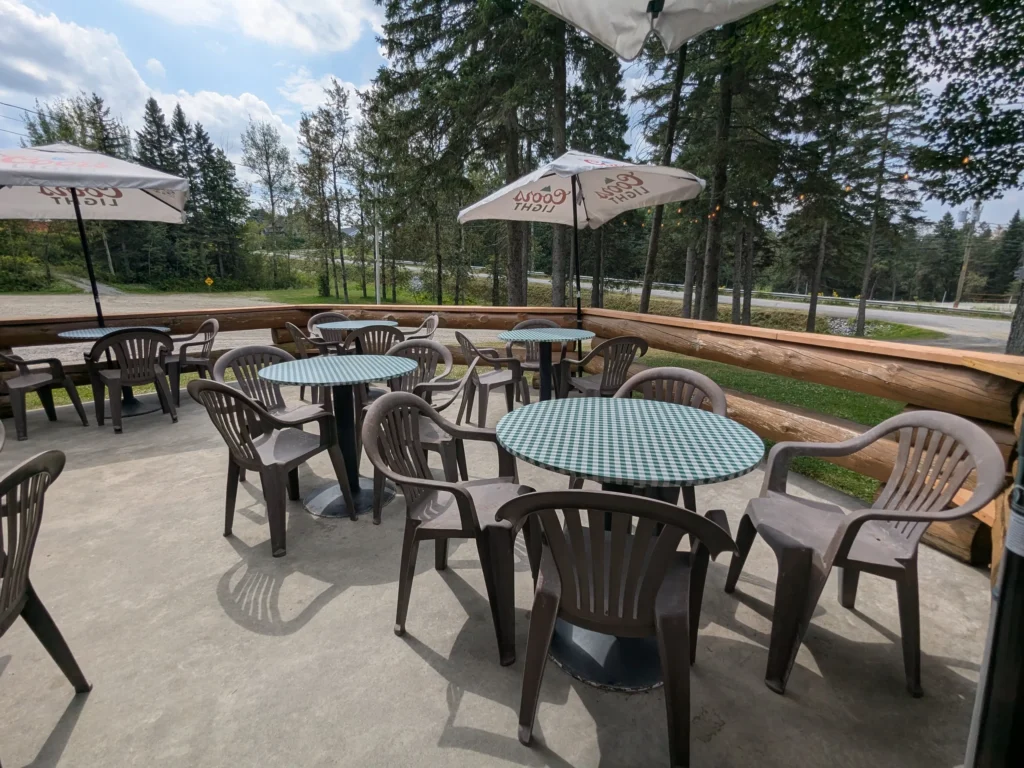 Terrasse avec tables et chaises en plastique.